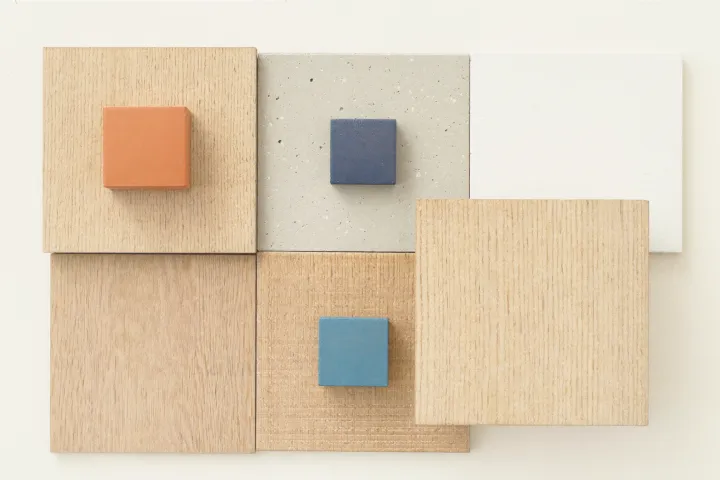 Maqueta cenital de materiales del Instituto —roble, microcemento, yeso y un detalle en terracota— encajados como las plantas de un edificio.
